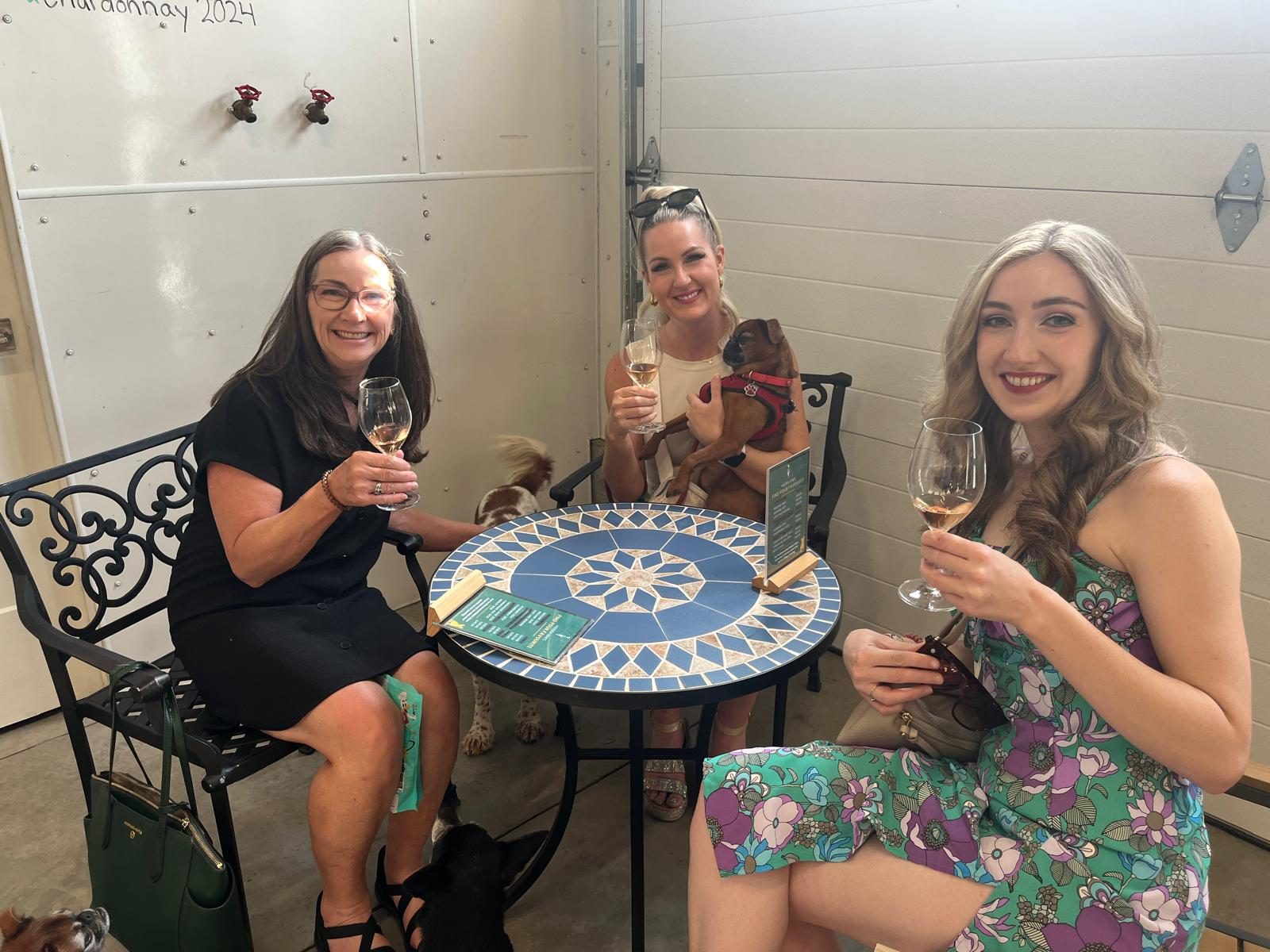 Katy and her family enjoying a Southeast Kelowna wine tasting with their dogs nearby
