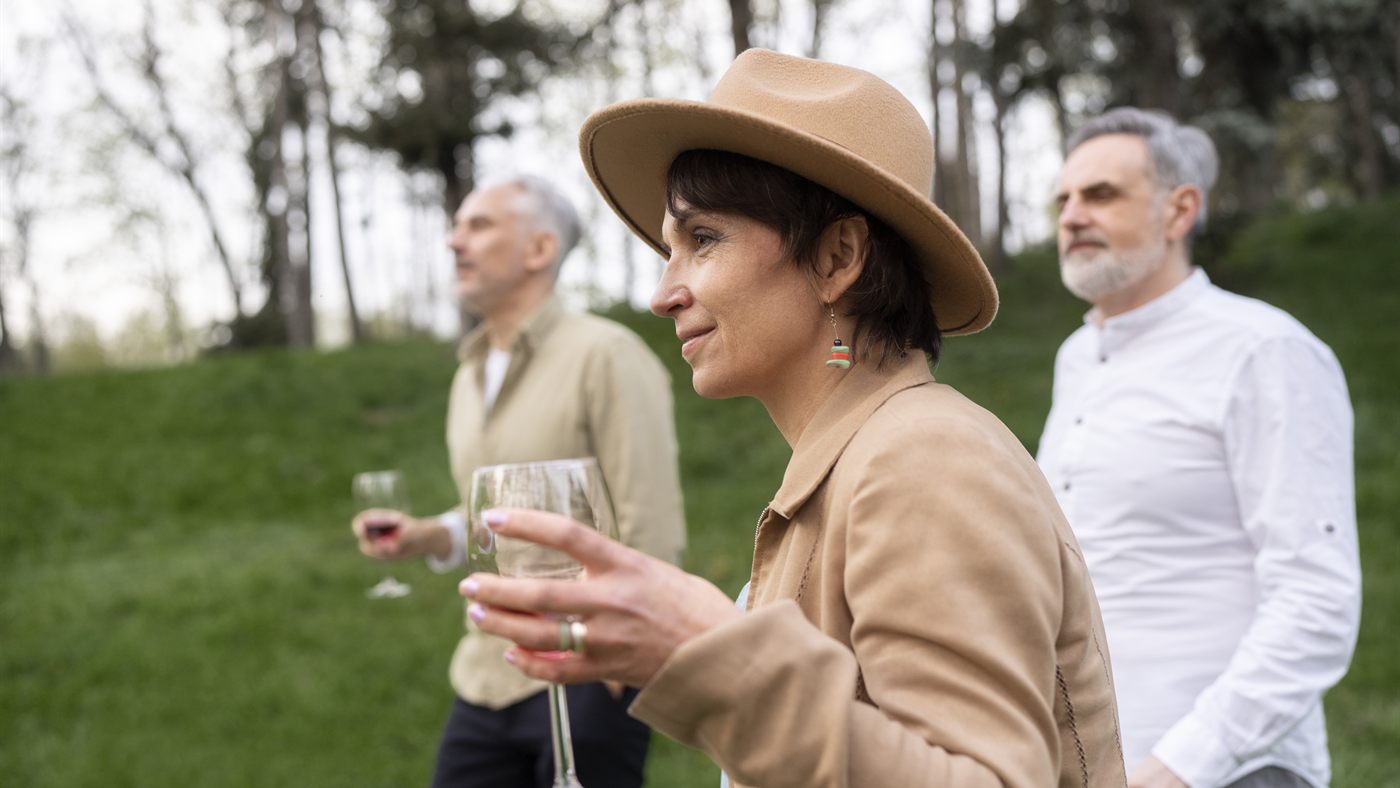 Senior guests walking outdoors with wine glasses during a Kelowna wine tour